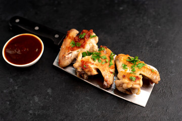 grilled chicken wings with sauce on stone background. selective focus with copy space for your text