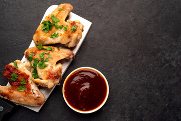 grilled chicken wings with sauce on stone background. selective focus with copy space for your text