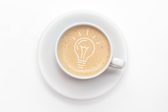 Cup of fresh coffee with light bulb icon in the froth concept for ideas, creativity and innovation. View from above