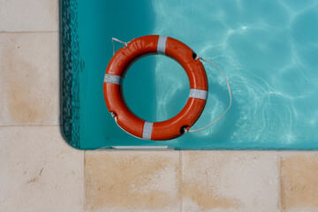 Red life buoy floating in swimming pool