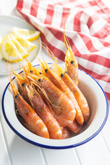 Boiled tiger prawns in bowl on white table. Tasty shrimps.