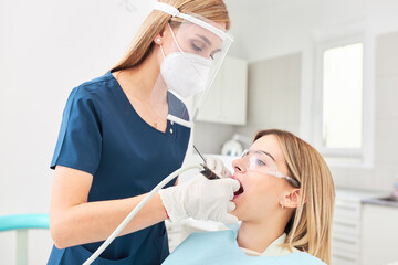 Young woman in dental clinic with female dentist.