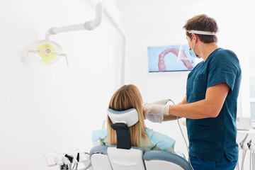 The dentist scans the patient's teeth with a 3d scanner.