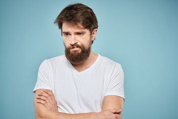 Obraz premium Man in white t-shirt lifestyle studio emotions facial expression blue isolated background