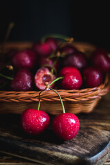Cherries in a wicker basket on a dark background.
