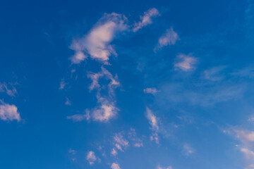 landscape of clouds in late day sky, golden sunlight reflecting on the nuves in blue sky