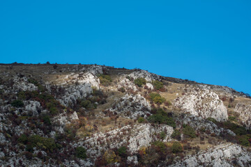 Fototapeta na wymiar Bulgarian countryside rock hill autumn shades sunny day green warm forest