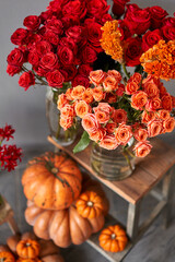 Obraz na płótnie Canvas Autumn mood. Set of pumpkins and orange and red flowers for Interior decorations. The work of the florist at a flower shop. Fresh cut flower.