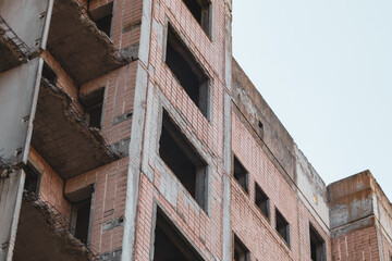 High multistorey abandoned soviet building facade with crashed balconies. Weathered housing estate, unfinished city of nuclear scientists in Birky, Ukraine