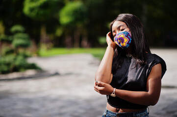 Fashionable african american woman, wear hand made face mask posing outdoor. New normal life.