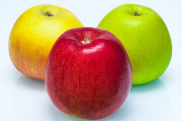 Three juicy ripe apples on a white background, close-up view.