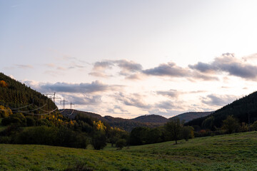Autumn sunset orange green vibrant landscape rural power lines clouds blue sky hillside forest trees beautiful bulgaria