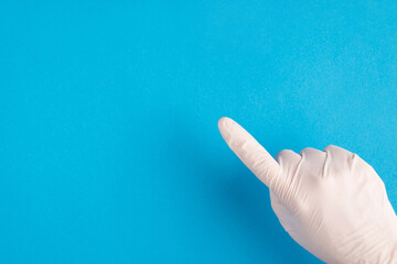 Top above overhead close up pov first person cropped view photo of doctor hand in white latex glove pointing forefinger on selected place isolated bright color blue background