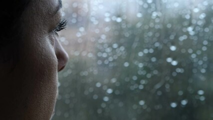 sadness, depression - pensive woman looks out the window in a rainy day - macro - Powered by Adobe