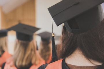 Women graduates of the university in square academic caps with tassel during graduation ceremony