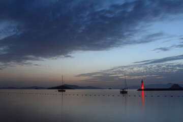 Seascape at sunset. Lighthouse on the coast. Seaside town of Turgutreis and spectacular sunsets