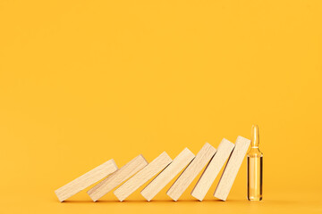 falling wooden blocks are stopped by an ampoule with vaccine. vaccination concept