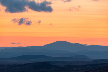 Fototapeta premium Landscape sunset colors over mountains and hills orange red yellow blue shades natural beauty bulgaria rural