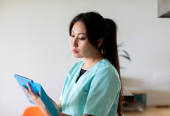 young nurse woman looking  with a tablet in a  doctor's office