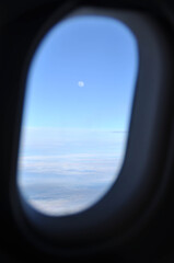 Moon above the clouds from the plane window