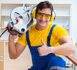 Repairman carpenter cutting sawing a wooden plank with a circula
