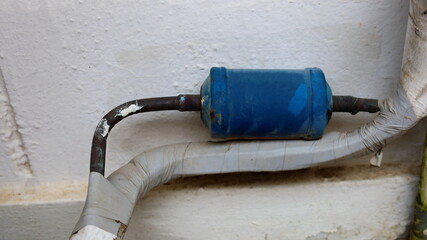 Dirty dry filter. Metal cylinder and blue insulation tube in refrigeration or air conditioning...