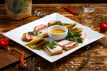 sandwich with lard and sauce in a plate on a wooden background