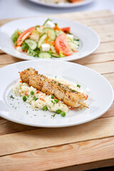 chicken kebab with rice and salad on the wooden background
