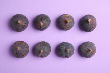 Delicious ripe figs on violet background, flat lay