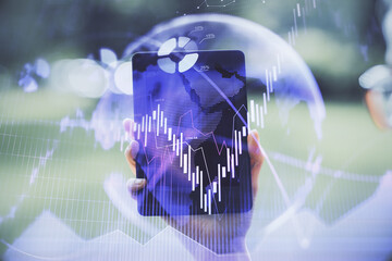 Double exposure of forex chart sketch hologram and woman holding and using a mobile device. Financial market concept.