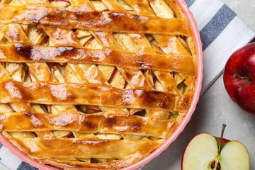 Traditional apple pie and fruits on light grey table, flat lay