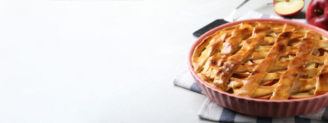Traditional apple pie on light table, space for text. Banner design