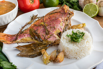 Roasted red fish (Olho de Cão in Brazil) seasoned with herbs, garlic, salt and lemon. Accompanying...