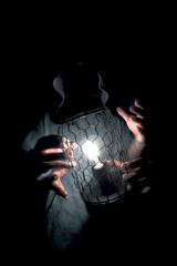 image of a person holding a lamp in a dark background