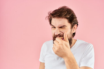 Naklejka premium Bearded man in white t-shirt gesturing with hands facial expression close up pink background