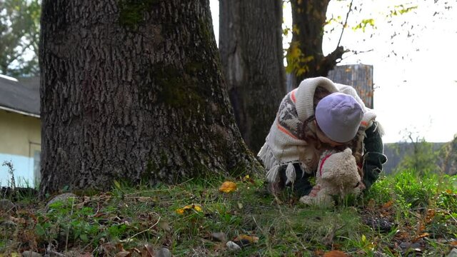 Little girl outdoor with teddy in autumn season.