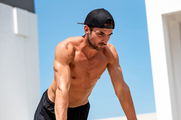 Shirtless handsome male bodybuilder doing push up workout outdoors, home exercise concept
