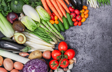 
fresh vegetables on the stone.

Fresh vegetables of different varieties are arranged on the left in a semicircle with space for text on the right on a gray stone background, top view, close-up.
