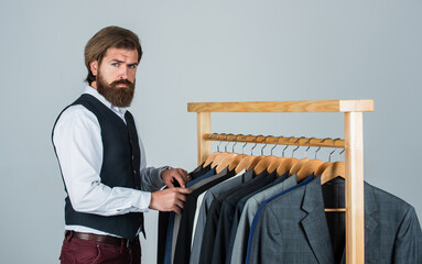 Bearded man customer looking for his size formal suit, vintage stock concept