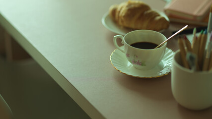 Breakfast meal with coffee cup and croissant on workspace