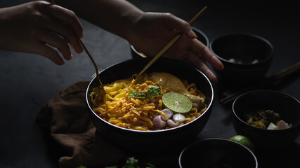 Female eating Noodles curry soup with Chicken (Khao Soi)