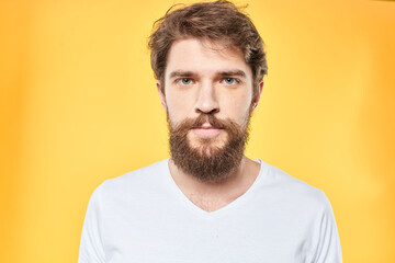 Fototapeta premium emotional bearded man in t-shirt cropped view yellow background studio