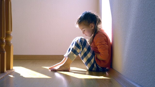 Mistreated child. Little girl on the floor sad. Child abuse concept.