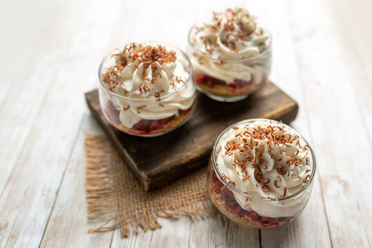 White Chocolate mousse dessert in a glass with raspberry and chocolate shavings  
