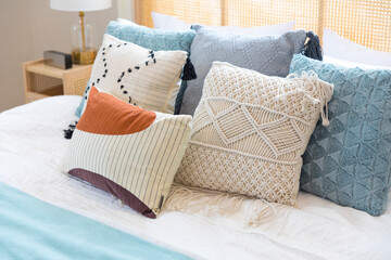 close up of new bed comfort with decorative pillows ,headboard and side table lamp.