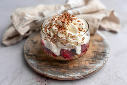 White Chocolate mousse dessert in a glass with raspberry and chocolate shavings  