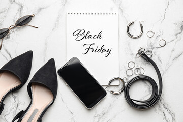 Notebook with text "Black Friday" and female accessories on white background