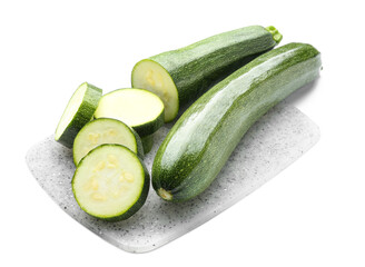 Board with fresh zucchini squashes on white background