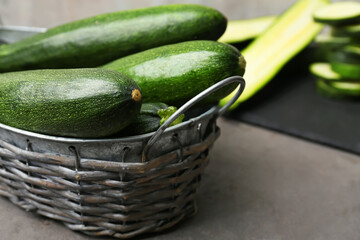 Basket with fresh zucchini squashes on grunge background