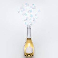 Bottle of champagne and confetti on white background. New Year celebration